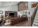 Bright living room with hardwood floors, a large brown leather couch, and staircase at 10759 N 101St St, Scottsdale, AZ 85260