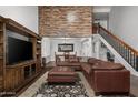 Bright living room showcasing a stylish brown leather couch, fireplace, and adjacent dining area at 10759 N 101St St, Scottsdale, AZ 85260