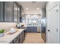 Modern kitchen features sleek, gray cabinets, stainless steel appliances, and stylish backsplash at 12239 W Caraveo Pl, Peoria, AZ 85383