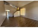 Spacious living room featuring vaulted ceilings, wood floors, and large windows for natural light at 12547 W Pasadena Ave, Litchfield Park, AZ 85340