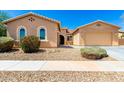 Inviting single-story home showcasing desert landscaping, a two-car garage, and a welcoming entrance at 16860 W Soft Wind Dr, Surprise, AZ 85387