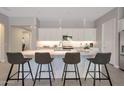 Bright, modern kitchen featuring a large central island with barstool seating and pendant lighting above at 16935 W Sheridan St, Goodyear, AZ 85395