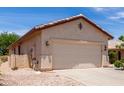 Attached two-car garage with beige siding, complemented by xeriscaped yard at 22508 W Antelope Trl, Buckeye, AZ 85326