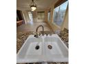 Bright kitchen featuring a stainless steel sink, granite counters, and an open layout to the living area at 22508 W Antelope Trl, Buckeye, AZ 85326