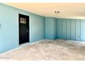 Covered carport area with freshly painted blue walls and a secure black front door at 2258 E Alpine Ave, Mesa, AZ 85204