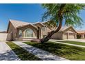 Charming two-story home boasts a three car garage, landscaped yard, and desert tree at 2723 N Winthrop --, Mesa, AZ 85213