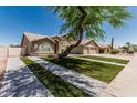 Charming two-story home boasts a three car garage, landscaped yard, and desert tree at 2723 N Winthrop --, Mesa, AZ 85213