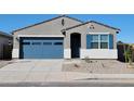 Stylish single-story home with a blue garage door and stone landscaping at 37153 W Prado St, Maricopa, AZ 85138