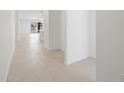 Bright hallway showcasing neutral tile flooring leading into an open-concept living area with a kitchen island at 37153 W Prado St, Maricopa, AZ 85138