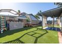 Well-maintained backyard featuring artificial turf and a covered patio area at 3833 W Phelps Rd, Phoenix, AZ 85053