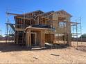 View of a new two-story home under construction with wood framing and scaffolding at 5681 E Iris Dr, Florence, AZ 85132