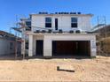 New home construction featuring scaffolding, exterior sheathing, and other building materials at construction site at 5701 E Iris Dr, Florence, AZ 85132