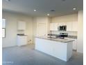 Modern kitchen featuring granite countertops, an island, stainless steel appliances, and bright lighting at 5701 E Iris Dr, Florence, AZ 85132