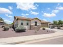 A single story home with tan stucco, a stone facade, desert landscaping, and a two-car garage at 6713 S 76Th Dr, Laveen, AZ 85339