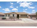 A well-maintained single story home with tan stucco, a stone facade, and desert landscaping at 6713 S 76Th Dr, Laveen, AZ 85339