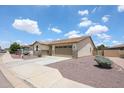 A well-maintained single story home with tan stucco, a stone facade, and desert landscaping at 6713 S 76Th Dr, Laveen, AZ 85339