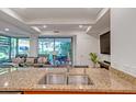 Granite countertops and stainless sink in a modern kitchen with views to the living room and outdoor space at 7157 E Rancho Vista Dr # 2012, Scottsdale, AZ 85251