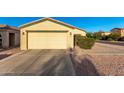 Two car garage door with desert landscaping, a tile roof, and neutral-toned stucco walls at 7317 S 37Th Gln, Phoenix, AZ 85041