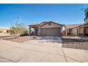 Inviting single-story home with a wide driveway and a well-manicured front landscape at 7405 W Elwood St, Phoenix, AZ 85043