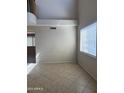 Bright living room with a large window and high ceilings with neutral paint and tile flooring at 7422 W Superior Ave, Phoenix, AZ 85043