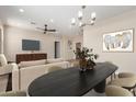 Open concept living area with a large dining table, modern chandelier, and a comfortable seating area with TV at 802 W Buist Ave, Phoenix, AZ 85041