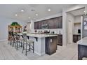 Well-lit kitchen showcases a breakfast bar, a kitchen island and stainless steel microwave at 10739 W Sierra Pinta Dr, Peoria, AZ 85373