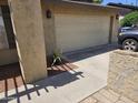 Garage door on a home with stucco exterior and a neatly maintained driveway at 12016 N 45Th Ave, Glendale, AZ 85304