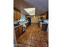 Spacious kitchen with wood cabinets, skylight, tile floor and black appliances at 12016 N 45Th Ave, Glendale, AZ 85304