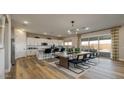 Bright open kitchen and dining area with modern appliances, an island with seating, and a dining table for six at 12712 W Corona Ave, Avondale, AZ 85323