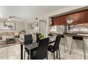 Open-concept dining area features a sleek black table and chairs, seamlessly connecting to the kitchen's breakfast bar at 1402 E Guadalupe Rd # 114, Tempe, AZ 85283