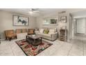 Cozy living room features tile floors, a ceiling fan, a comfortable couch, and an eye-catching accent rug at 1402 E Guadalupe Rd # 114, Tempe, AZ 85283