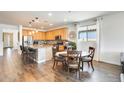 Bright eat-in kitchen featuring wood floors, stainless appliances, granite counters, and a breakfast table at 14393 W Wethersfield Rd, Surprise, AZ 85379