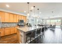 Well-lit kitchen featuring a center island with barstool seating, stainless steel appliances, and open layout at 14393 W Wethersfield Rd, Surprise, AZ 85379