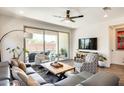 Comfortable living room showcasing a sectional sofa, decorative pillows, and sliding door access to the pool at 14393 W Wethersfield Rd, Surprise, AZ 85379