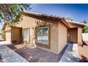 Exterior view of a home featuring a stylish front door, tiled roof, and low-maintenance desert landscaping at 2822 N 90Th Ave, Phoenix, AZ 85037