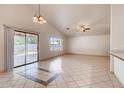 Spacious living room boasts tile flooring, vaulted ceilings, sliding door access, and bright natural light at 2822 N 90Th Ave, Phoenix, AZ 85037