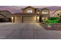 Inviting two-story home featuring a spacious three-car garage with stone accents and manicured front yard at 31453 N Blackfoot Dr, San Tan Valley, AZ 85143