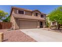 Two-story home with a large driveway and desert landscaping, providing ample parking and curb appeal at 3274 E Denim Trl, San Tan Valley, AZ 85143
