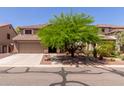 Charming two-story home featuring desert landscaping and a large shade tree in the front yard at 3274 E Denim Trl, San Tan Valley, AZ 85143