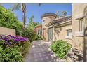 Picturesque single-story home featuring a turret entry, mature landscaping, and a brick-paved walkway at 3406 E Pyrenees Pass, Phoenix, AZ 85018