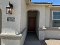 Inviting entryway features a classic front door, stylish outdoor lantern, and clear address plaque at 38070 W Frascati Ave, Maricopa, AZ 85138