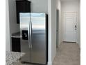 Stainless steel refrigerator stands next to a pantry and an entrance to a tiled kitchen area at 38070 W Frascati Ave, Maricopa, AZ 85138