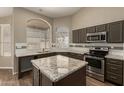 Well-equipped kitchen features granite counters, tiled backsplash, stainless steel appliances, and a center island at 3946 N 112Th Ave, Avondale, AZ 85392