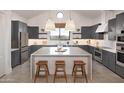 Spacious kitchen with modern grey cabinetry, stainless steel appliances and a large center island at 42065 N Cutbow Trl, San Tan Valley, AZ 85140