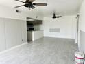 Open living room area with tile flooring and partial kitchen view at 4242 N 69Th Dr # 1303, Phoenix, AZ 85033