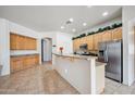 Bright kitchen featuring ample wood cabinetry, granite countertops, stainless steel appliances, and tile flooring at 4414 W Monte Way, Laveen, AZ 85339