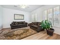 Cozy living room showcasing hardwood floors, plantation shutters, comfortable seating, and a decorative rug at 4414 W Monte Way, Laveen, AZ 85339