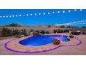 Inviting pool area featuring an elegant stone border, water feature, and mountain views at 5306 N 188Th Ln, Litchfield Park, AZ 85340
