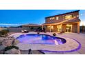 Beautiful backyard pool with elegant stone border and landscaped features for outdoor enjoyment at 5306 N 188Th Ln, Litchfield Park, AZ 85340