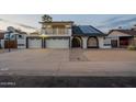Lovely two-story house with solar panels, an upper deck, a two-car garage and front yard landscape at 6216 W Poinsettia Dr, Glendale, AZ 85304